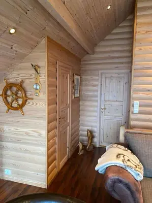a room with a wooden wall with a bed in it at Moderne Rorbu helt i sjøkanten in Hauge