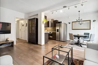 a living room with a table and a kitchen at Stylish & Modern Apartment, in Centre, Free Parking spot ! in Trondheim