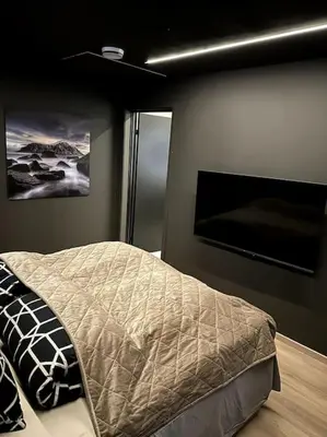 a bedroom with a bed and a flat screen tv at Enebolig Trondheim, familievennlig, nytt 2023 in Trondheim