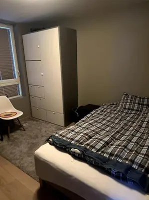 a bedroom with a bed and a cabinet and a table at Enebolig Trondheim, familievennlig, nytt 2023 in Trondheim