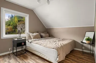 a bedroom with a bed and a window at Trolltunga Fjord View in Tokheim