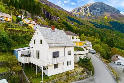 a white house on the side of a mountain at Trolltunga Fjord View in Tokheim