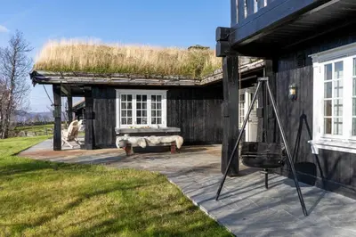 a building with a grass roof with a bench at Tovebu Superior 9-sengshytte in Geilo