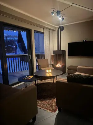 a living room with a table and a fireplace at Chalet Chablis in Hemsedal