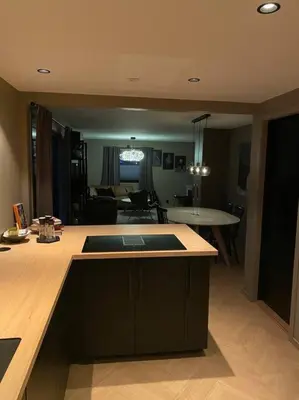a kitchen with a counter top and a living room at Totalrenovert enebolig i rolige omgivelser in Trondheim
