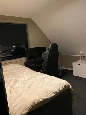 a bedroom with a bed and a desk with a computer at Totalrenovert enebolig i rolige omgivelser in Trondheim