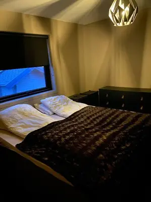 a bedroom with a bed with a large window at Totalrenovert enebolig i rolige omgivelser in Trondheim