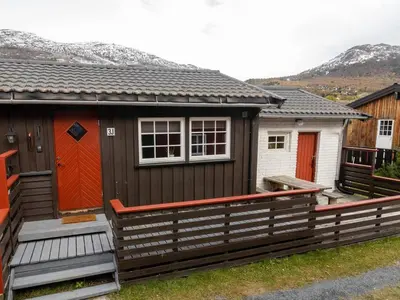 a small house with red doors and a fence at Cozy apartment close to the ski resort in Oppdal