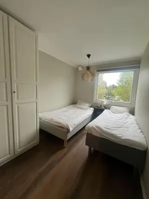 two beds in a room with a window at Bolig til leie under ski-VM 2025 in Trondheim