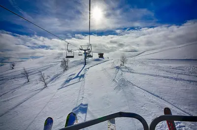 a person riding a ski lift in the snow at Old Cabin Vibe, Perfect For Families Or Couples in Beitostøl