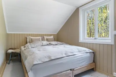 a bedroom with a bed and a window at Rindalsskogen cabin in Løfald