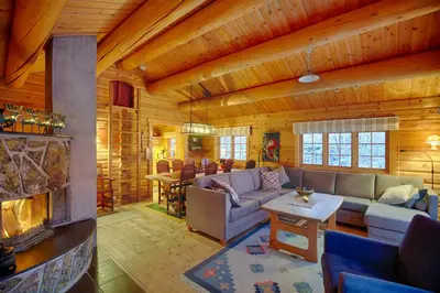 a living room with a fireplace in a log cabin at Perfectly Located Timber Cabin For 6-8 Guests in Beitostøl