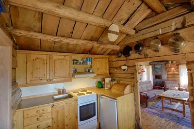a kitchen with wooden cabinets and a stove top oven at Charming Cabin With Old Timber, Fireplace & Views in Beitostøl