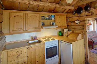 a kitchen with wooden cabinets and a stove top oven at Charming Cabin With Old Timber, Fireplace & Views in Beitostøl