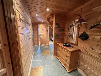 a hallway of a cabin with wooden walls and a table at Familiehytte Med Peis Og Badstu I Sentrum in Beitostøl