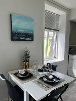 a white dining room table with chairs and a window at Hellegata 5 - in the heart of Ålesund in Ålesund