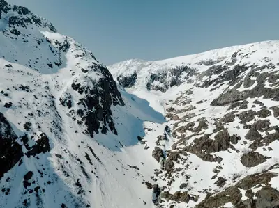 a snow covered mountain with a lake in the middle at Odda Trolltunga Atmosphere in Odda