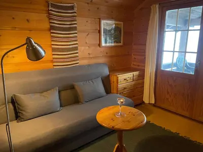 a living room with a couch and a table at Koselig Sentral Eldre Hytte Med Peis in Beitostøl