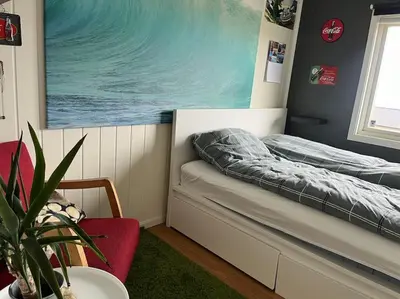 a small bedroom with a bed and a potted plant at Eget rom og bad med delt kjøkken, 15 minutter fra Trondheim in Malvik