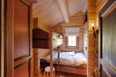 a bedroom with a bunk bed in a log cabin at Mountain Getaway With Sauna And Views in Beitostøl