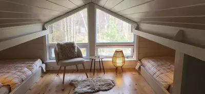 a small room with two beds and a window at Cabin on an beautiful island with a sea view in Vinsternes