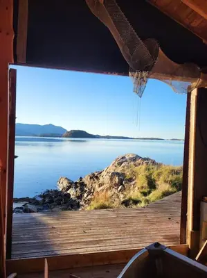 a window with a view of a body of water at Cabin on an beautiful island with a sea view in Vinsternes