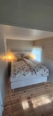 a bedroom with a bed with two lamps on it at Cabin on an beautiful island with a sea view in Vinsternes