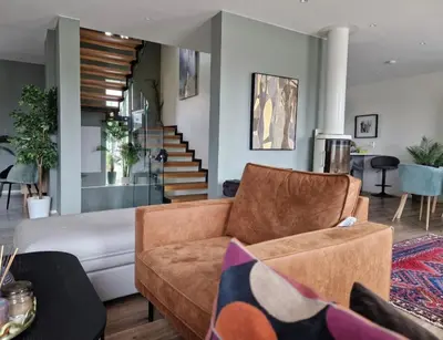 a living room with a couch and a staircase at Ski-VM i Trondheim 2025, house with 5 big bedrooms in Trondheim