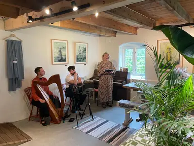 a woman standing in a room with two people in a room at Ner-Grefstad gard in Kallstad