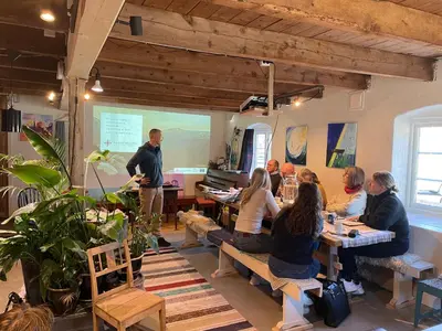a group of people sitting at tables in a room at Ner-Grefstad gard in Kallstad