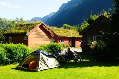 a couple of people sitting at a table next to a tent at Bøyum Camping in Fjarland