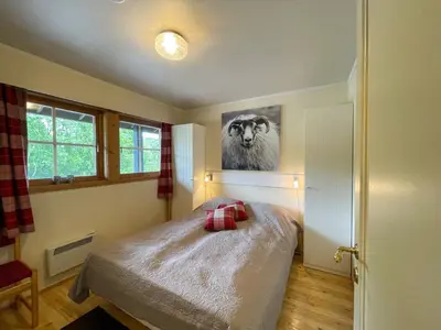 a bedroom with a bed and a picture of a cow at Perfect Retreat For Small Families in Beitostøl