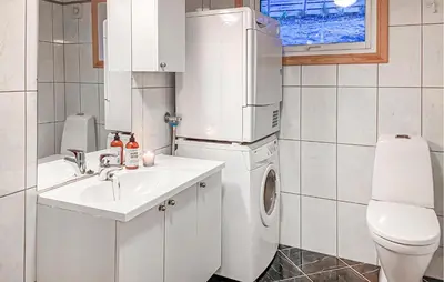 a bathroom with a sink and a washer and dryer at 4 Bedroom Awesome Home In Luster in Luster