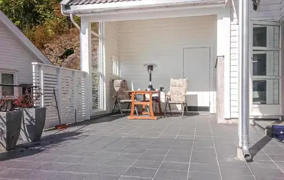 a patio with a table and chairs on a house at 4 Bedroom Awesome Home In Luster in Luster