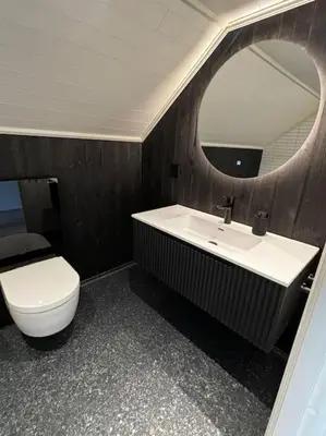 a bathroom with a sink and a toilet and a mirror at NY og moderne studioleilighet med elbil lading in Gjøvik