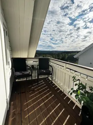 a balcony with two chairs and a table on a porch at NY og moderne studioleilighet med elbil lading in Gjøvik