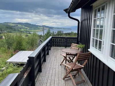 a balcony with a table and chairs on a house at 8 person holiday home in frosta in Vollen