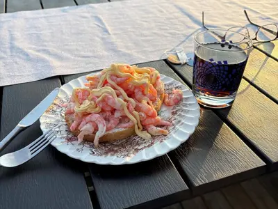 a plate of food with shrimp and a drink on a table at 8 person holiday home in frosta in Vollen