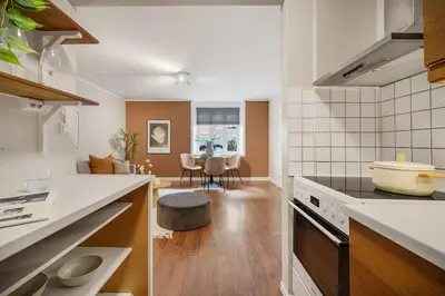 a kitchen with a stove and a living room at Leilighet - midt i sentrum! in Bergen
