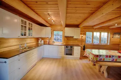 a kitchen with white cabinets and a wooden ceiling at Large Cabin Retreat Perfect For Family Gatherings in Beitostøl