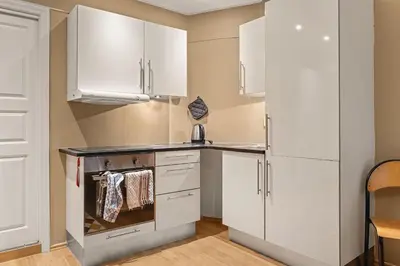 a kitchen with white cabinets and an oven at DINBNB Apartments l Historical Building I 100m To University Museum in Bergen