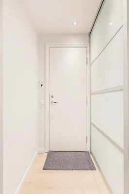 an empty hallway with a white door and a rug at DINBNB Apartments l Historical Building I 100m To University Museum in Bergen