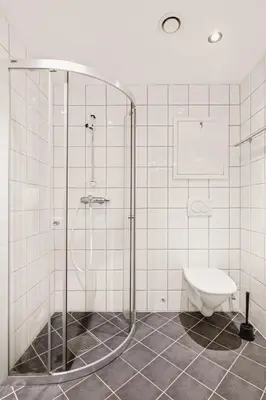 a bathroom with a shower and a toilet at DINBNB Apartments l Historical Building I 100m To University Museum in Bergen