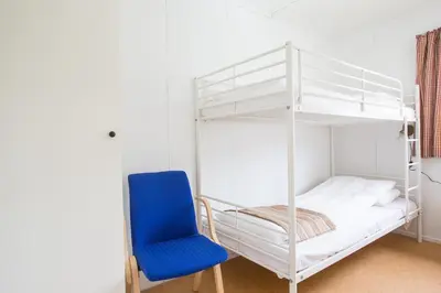 a bedroom with a bunk bed and a blue chair at Sauda Fjord Camping in Saudasjøen