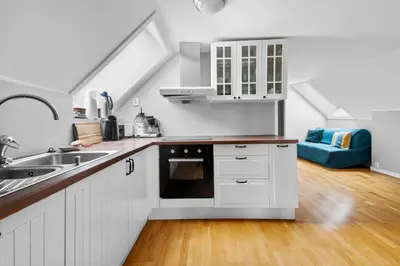 a kitchen with white cabinets and a sink at Experience Norway's History I With Free Parking in Bergen
