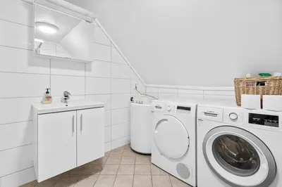 a white laundry room with a washer and dryer at Experience Norway's History I With Free Parking in Bergen