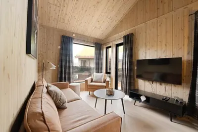 a living room with a couch and a tv at Mosetertoppen Skistadion - Hafjell Ski Resort in Hafjell