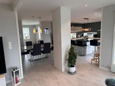 a living room and kitchen with a table and chairs at Enebolig Trondheim syd in Trondheim