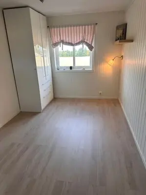 an empty room with a wooden floor and a window at Enebolig Trondheim syd in Trondheim