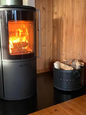 a stove with a fire in a room at Tørresvangen in Tynset